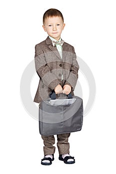 Young boy in grey suit and bow tie standing and looking on camera (isolated on white)