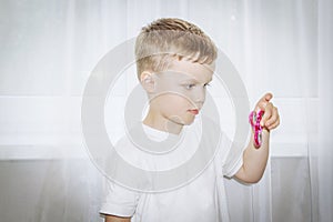 Young boy hand holding popular fidget spinner toy