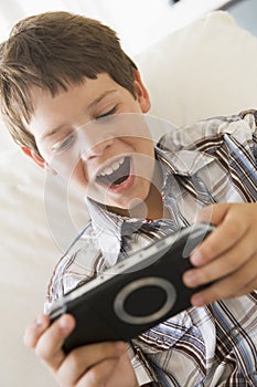 Young boy with handheld game indoors