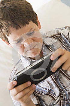 Young boy with handheld game indoors photo