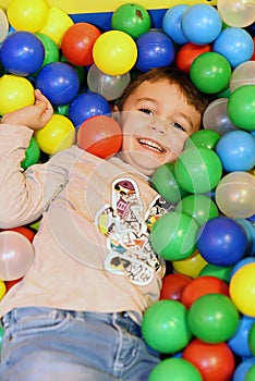 Young boy having fun in colored balls