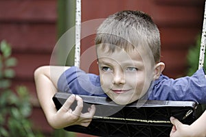 Young boy having fun outside on a swing