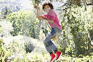 Young Boy Having Fun On Rope Swing