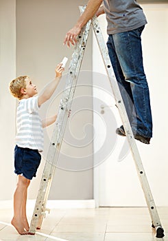 He loves assisting dad. Young boy helping his father with changing a lightbulb.