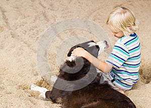 Young boy with his arm around his dog