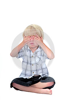 Young boy with his hands over his eyes and white background