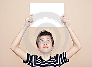 Young boy holding blank white board