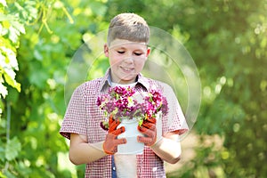 Boy holding bucket with flowers