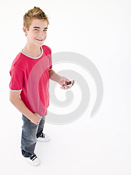 Young boy holding cellular phone and smiling