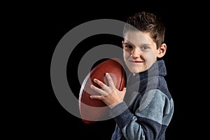 Young Boy Holding Football Like Quarterback