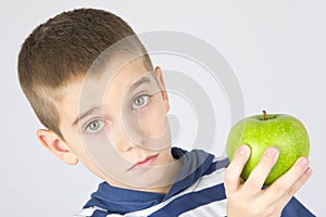 Young boy holding fresh green apple