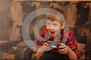 Young boy holding gamepad and playing video games