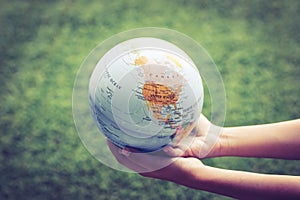 A young boy holding a globe. The concept of protecting nature, ecology and global peace