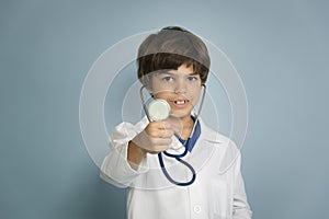 Young boy holding out blue stethoscope