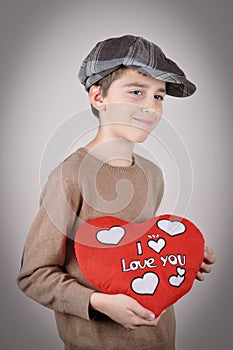Young boy holding a plush red heart