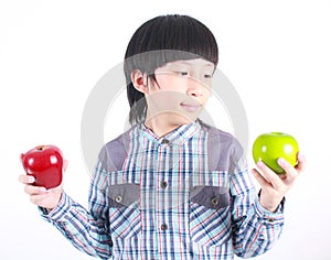 Young boy holding red and green apple