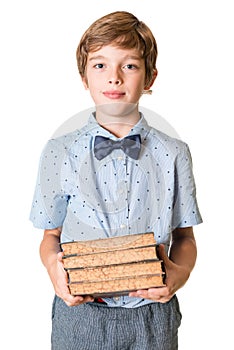 Young boy holding stack of books