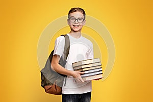 Young Boy Holding Stack of Books