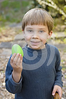 Young boy holds up easter egg