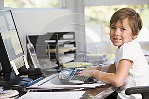 Young boy in home office with computer