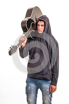 Young boy in hoodie standing with his guitar on the shoulder