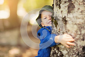 Young boy hugging a tree