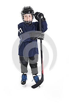 Young boy in ice hockey gear against white