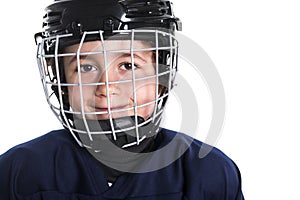 Young boy in ice hockey gear against white