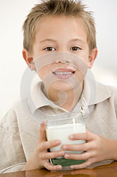 Young boy indoors drinking milk