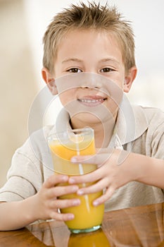 Young boy indoors with orange juice