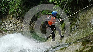 Young Boy With Instructor Rappelling A Huge Waterfall In Ecuadorian Andes