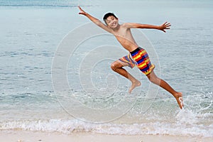 Young boy jumping on the beach