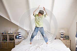 Young Boy Jumping On His Bed