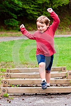 Young boy jumping over obstacle