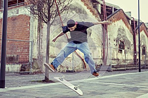 Young boy jumping with skateboard in outskirt