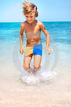 Young boy jumping on the water at the sea