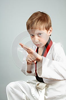 Young boy in a karate suit practicing martial arts looking menacing