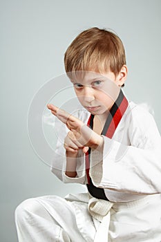 Young boy in a karate suit practicing martial arts looking menacing photo