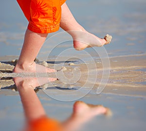 Young Boy Kicking Sand