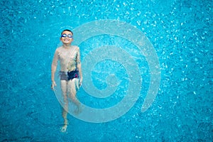 Young boy kid having fun swimming in pool