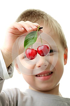 Young boy (kid) holding cheries