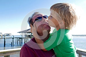 Young boy kissing his father