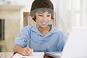 Young boy with laptop doing homework