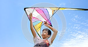 Young boy launchs a kite on a clear summer day on a background of blue sky on vacation photo
