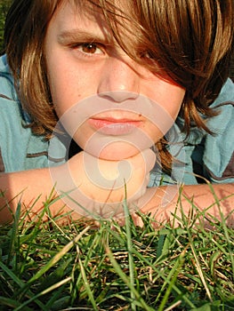 Young boy laying in grass