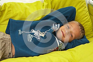 Young boy laying on pillows