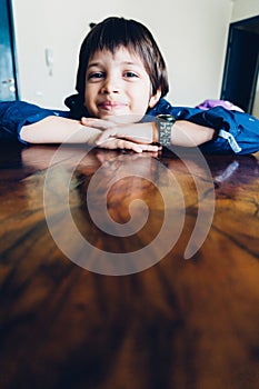 Young boy leaning on table