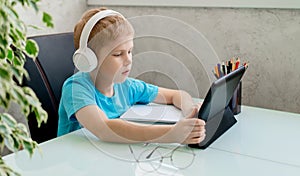 Young boy learn by tablet at home. Distance learning in quarantine. Isolation. Homework photo