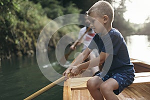 Young boy learn to paddling canoe