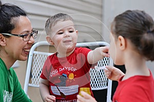 young boy learning how to blow soap bubbles